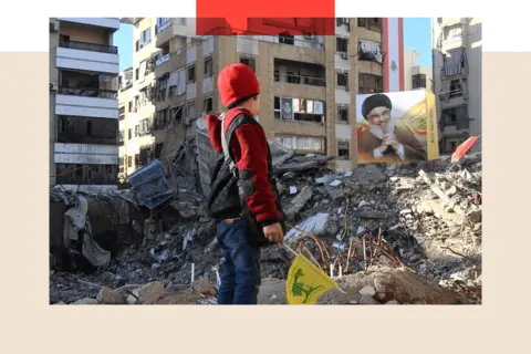 Getty Images A young boy stands in front of a large portrait of Hezbollah's former leader Hassan Nasrallah, seen among damaged buildings