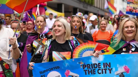 Festival-goers wave rainbow flags - a symbol of lesbian, gay, bisexual, transgender and queer pride - as they march along Newcastle's Northumberland Street during a previous Pride festival.