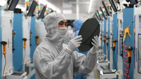 Getty Images Employees work on the production line of silicon wafer at a factory of GalaxyCore Inc. on May 25, 2021 in Jiashan County, Jiaxing City, Zhejiang Province of China.