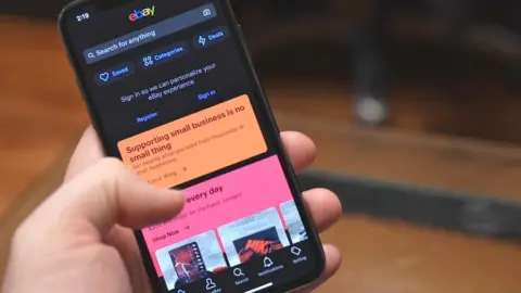 eBay A hand scrolling the eBay mobile app