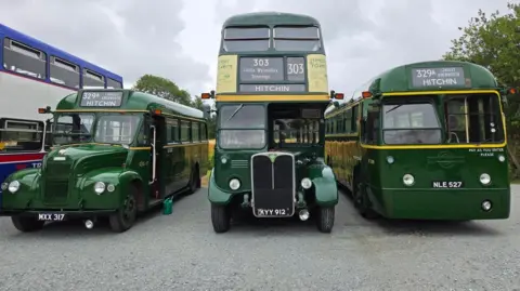Wesley Tierney Three old buses parked next to each other. All three are green with "HITCHIN" written on the front indicating their destination.