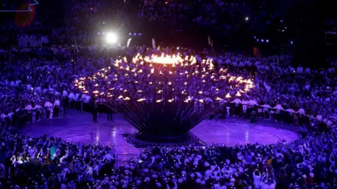 Hundreds of people stand around the cauldron during the London 2012 Olympics opening ceremony.