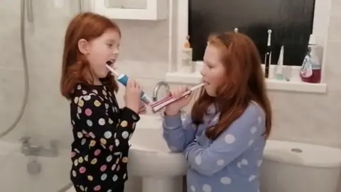 Family picture Two of Jodi Hayes' children brushing their teeth