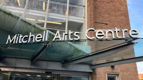 The entrance to a theatre building with "Mitchell Arts Centre" displayed over the doors in large white letters.