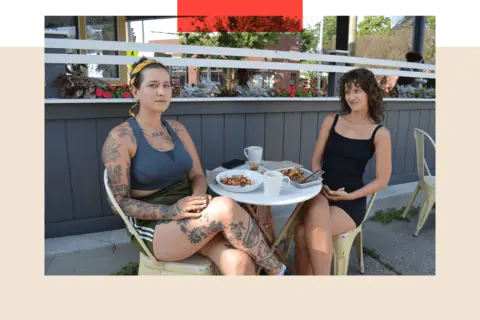 Two women sitting outside a cafe