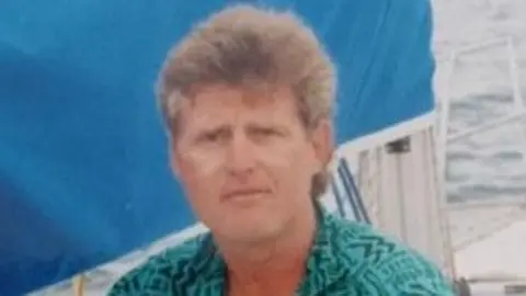 Family handout Farmer Thomas Olverson wearing a green shirt, sitting on a yacht on a body of water