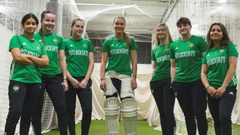 Players pose against backdrop of practice nets