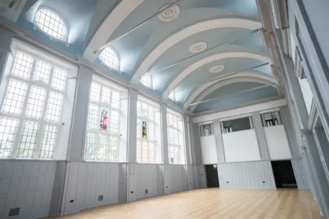 Amber Valley Borough Council Interior of a refurbished grammar school, with hard flooring and pale blue paint decor.