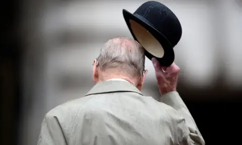 Reuters Britain's Prince Philip pictured from behind as he doffs his hat on 2 August, 2017.