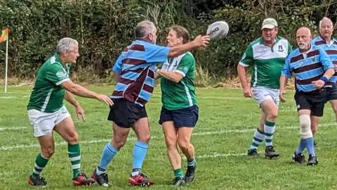 Elaine Pamplin Kingswood walking rugby players contest the ball during a match