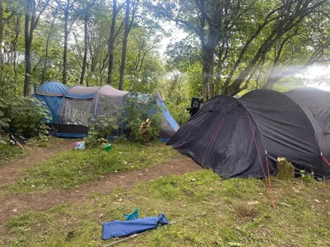 Emily Crichton Two large tents in a wooded area