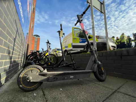 E-bikes and scooters parked near police officers