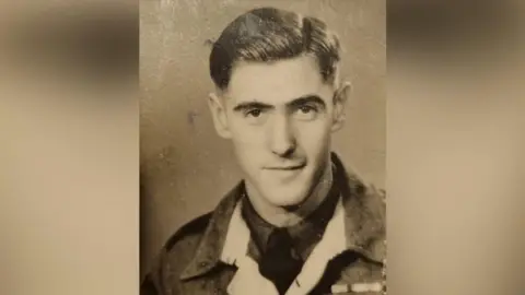 Royal Navy Mr Eskdale as a young man wearing his military uniform with swept back hair.