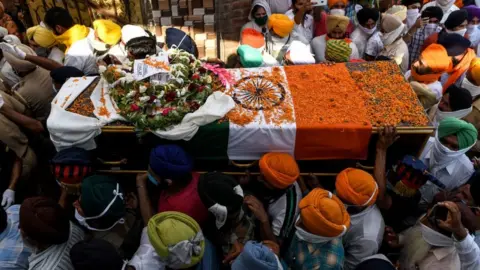 Getty Images Family members and villagers carry the coffin of soldier Satnam Singh who was was killed in a recent clash with Chinese forces in the Galwan valley area, during the cremation ceremony at Bhojraj village near Gurdaspur on June 18, 2020