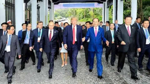 AFP Donald Trump walks next to Vladimir Putin and other world leaders on the way to the "family photo" at the Apec summit