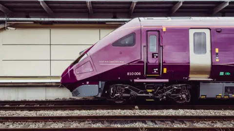 East Midlands Railway Picture of the front of a train - the class 810 - on a railway line.