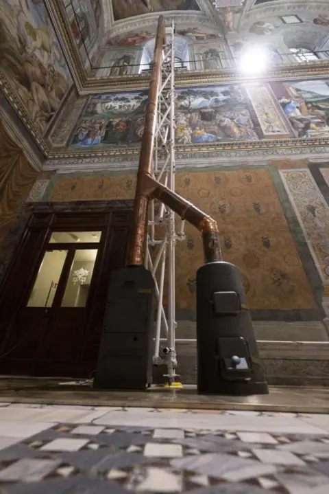 EPA Image shows the two stoves and the chimney installed inside the Sistine Chapel ahead of the conclave