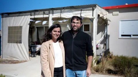 BBC / Joe McNally Elik Goldberg and his wife Hodaya standing outside the front of their home