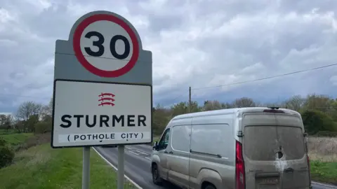 Simon Dedman/BBC The sign for Sturmer in Essex with in brackets (Pothole City)