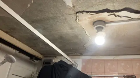 Bathroom ceiling with missing plasterboard
