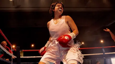 Black Bear Sydney Sweeney in Christy, wearing a bear of boxing gloves while fighting in the ring