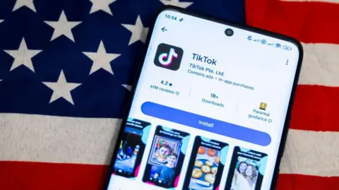 TikTok app logo on a smartphone screen displayed with the American flag January 2025.