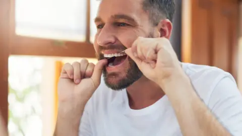 Getty Images A man flossing