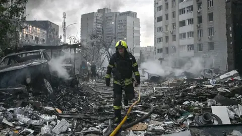 A rescuer walks through the wreckage of a building in Kyiv.