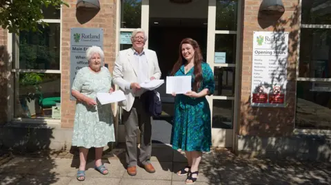 Alicia Kearns Two women and a man holding a petition
