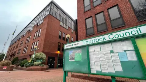 Stuart Woodward/BBC Building of Thurrock Council with green sign in front.