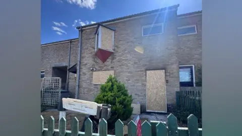 Supplied The outside of the house, with the windows and door boarded up.