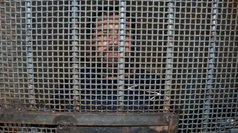 Mauricio Torres/EPA Alias Fito is pictured behind the bars of a prison door in La Roca prison