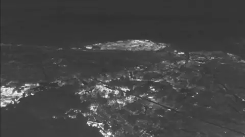Suffolk Lowland Search and Rescue A black and white thermal image from a drone at a wildfire. There are lighter areas that reveal the hotspots.
