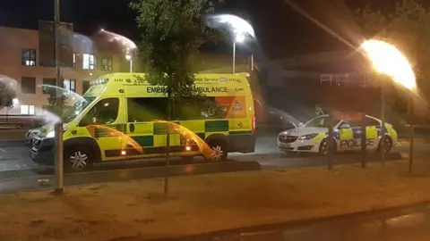 An ambulance and police car outside the emergency department at the hospital