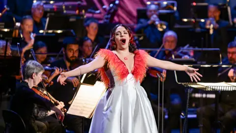 Julieth Lozano Rolong performing in a white and red gown