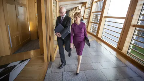 Getty Images Scottish First Minister Nicola Sturgeon and Deputy First Minister John Swinney arrive ahead of First Minister's Questions (FMQ's) in the debating chamber of the Scottish Parliament on March 19, 2020 in Edinburgh