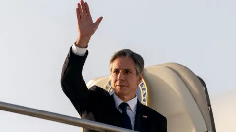 Getty Images Antony Blinken waves as he exits his plane