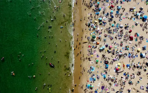 Hannah McKay / Reuters People and children enjoy the hot weather at Bournemouth Beach, 17 June 2022
