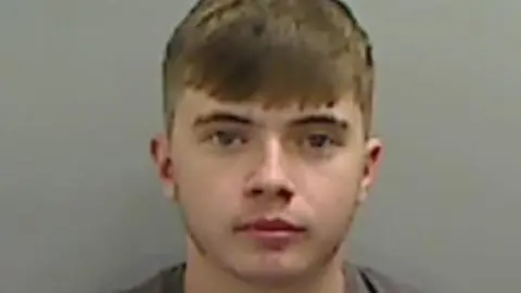 Mugshot of Lewis Herman. He is young looking with no facial hair and short fair hair.