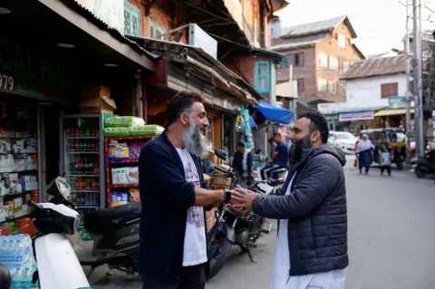 Reuters Kashmiri men greet each other after the ceasefire announcement between India and Pakistan, in Srinagar, May 10, 2025. REUTERS/Sharafat Ali