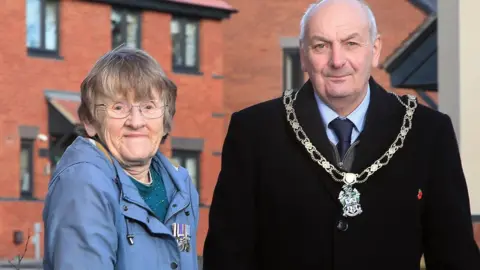 Mrs Susan Brelsford stood with Councillor Robert Bullock at a street sign.