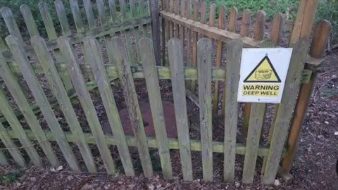 Norfolk Police Image shows disused well top enclosed in a triangular picket fence