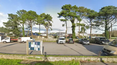 A car park by a playing park.