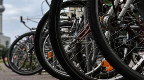 A close up image of a numerous bike wheels on a street. 