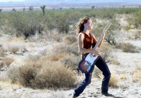 Getty Images Sheryl Crow plays her guitar in the desert