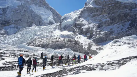 Reuters Members of an expedition team hike at Khumbu Icefall, as the route to Mount Everest Camp One has not yet been opened
