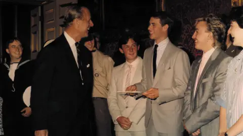 Stuart Robertson The Duke with his father, Prince Philip, at St James's Palace, in 1986. They are surrounded by people, all of them in formal wear.