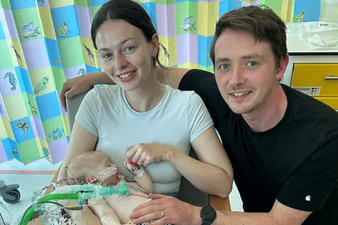 Family Photo Macs is being held by parents Catrin and Dylan Green while in hospital