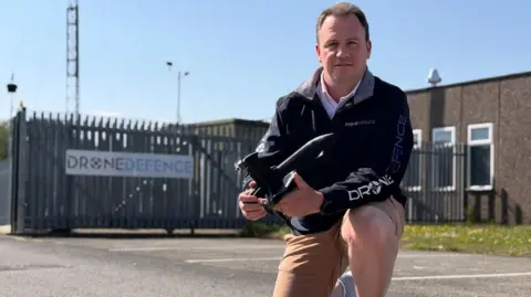 Man holding drone defensive technology in front of firm's 