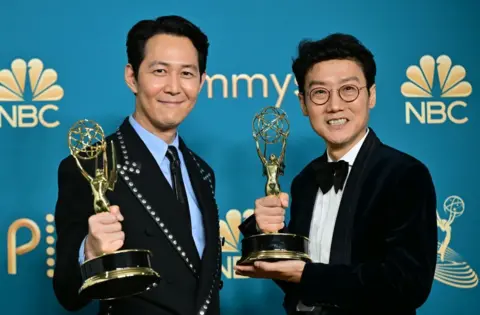 Getty Images South Korean actor Lee Jung-jae (L) poses with the award for Outstanding Lead Actor In A Drama Series and South Korean director Hwang Dong-hyuk (R) with the Emmy for Outstanding Directing For A Drama Series for "Squid Game" during the 74th Emmy Awards at the Microsoft Theater in Los Angeles, California, on September 12, 2022. 